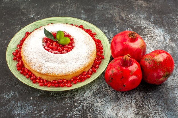 Seitenansicht ein appetitlicher Kuchen ein appetitlicher Kuchen mit Granatapfelkernen und drei Granatäpfeln