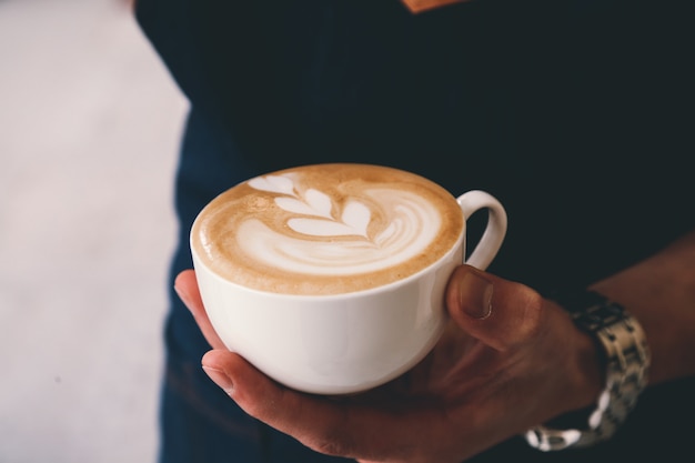 Seitenansicht ein Mann, der eine Tasse Cappuccino trinkt