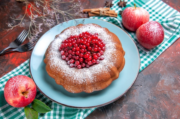 Kostenloses Foto seitenansicht einen kuchen ein kuchen äpfel mit blättern auf der karierten tischdecke zimtgabeln