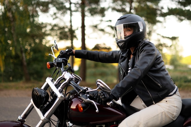 Kostenloses Foto seitenansicht einer älteren frau mit motorrad