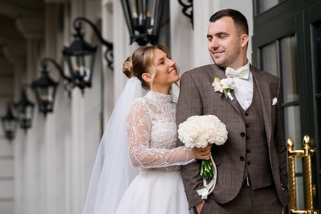 Kostenloses Foto seitenansicht einer atemberaubenden blonden frau mit natürlichem make-up, gekleidet in einem eleganten kleid, das mit spitze und perlen verziert ist