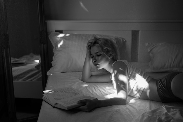 Seitenansicht einer Frau, die im Bett liest