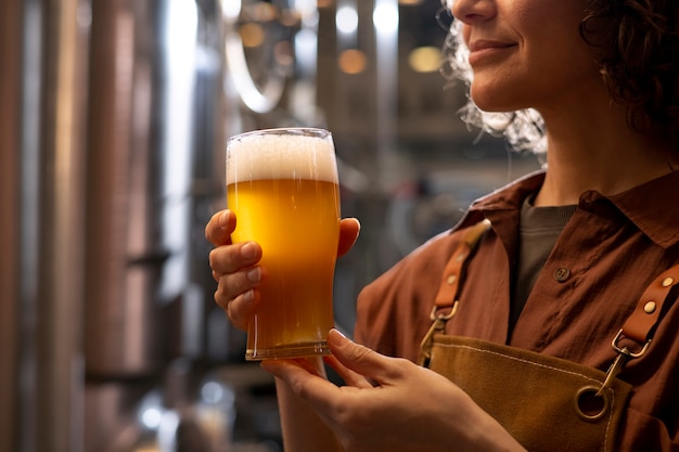 Kostenloses Foto seitenansicht einer frau, die in einer bierfabrik arbeitet