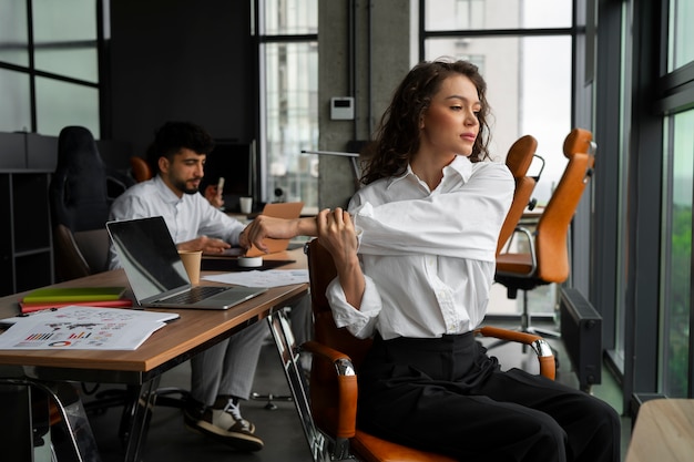 Mitarbeiter beim Yoga im Büro - Betriebliches Gesundheitsmanagement