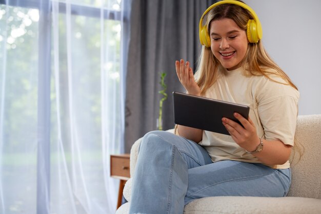 Seitenansicht einer Frau, die Videoanrufe mit einem Tablet tätigt