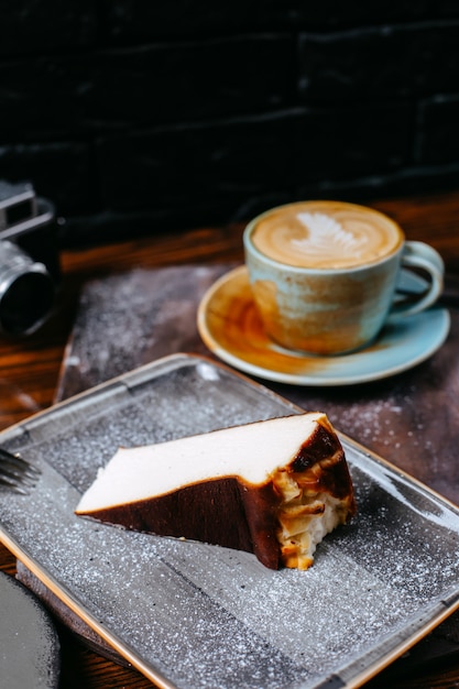 Seitenansicht einer Tasse Kaffee Latte serviert mit Käsekuchen