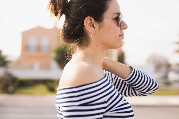 Seitenansicht einer tragenden Sonnenbrille der jungen Frau, die weg schaut