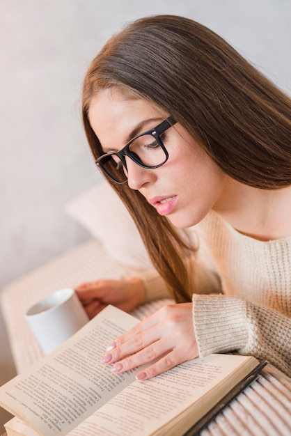 Kostenloses Foto seitenansicht eines buches der jungen frau lese