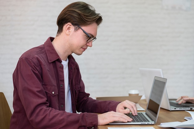 Seitenansicht eines Jungen, der während der Gruppensitzung einen Laptop benutzt