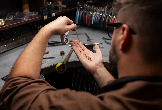 Kostenloses Foto seitenansicht eines juweliers, der schmuck herstellt