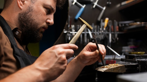 Kostenloses Foto seitenansicht eines juweliers, der schmuck herstellt