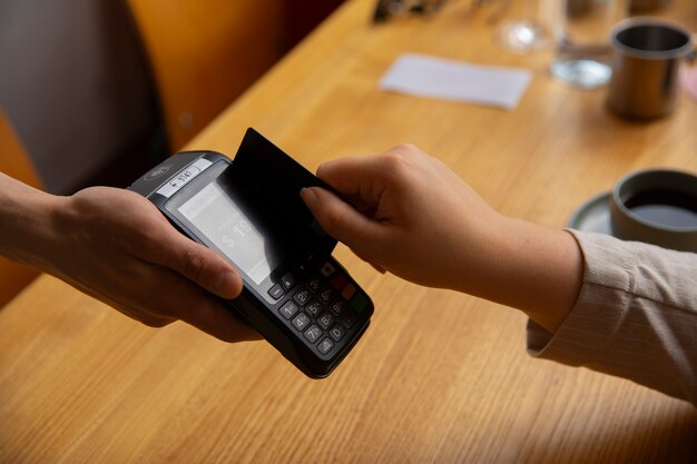 Seitenansicht eines Kunden, der mit einem NFC-Gerät bezahlt