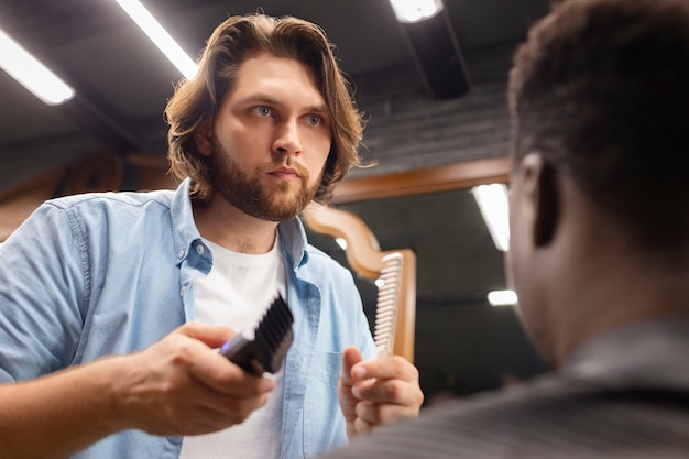 Kostenloses Foto seitenansicht eines mannes, der sich die haare schneiden lässt