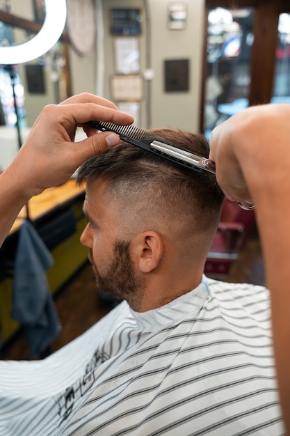 Seitenansicht eines Mannes, der sich die Haare schneiden lässt