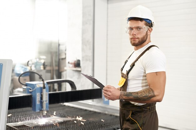 Seitenansicht eines starken Mechanikers in der Schutzbrille