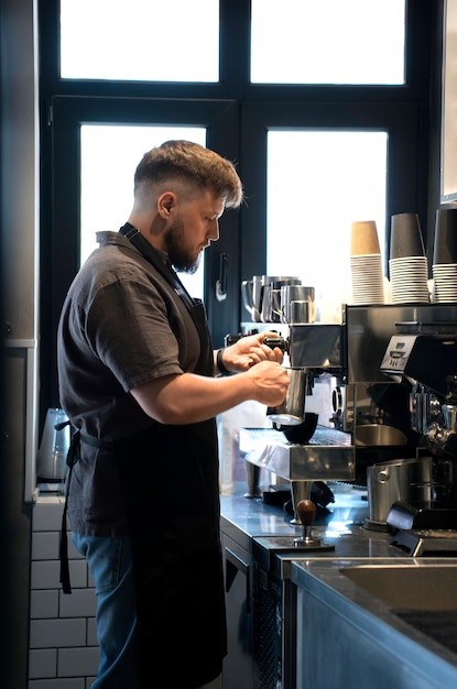 Seitenansicht eines übergroßen Mannes, der als Barista arbeitet