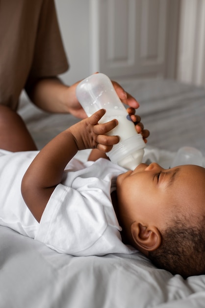 Kostenloses Foto seitenansicht erwachsener, der baby füttert