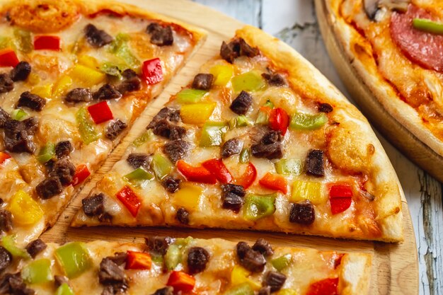 Seitenansicht Fleischpizza mit rotem gelbem und grünem Paprikafleisch und Käse