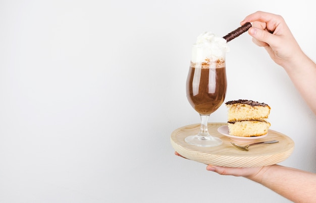 Seitenansicht frappe und Kuchen auf einer hölzernen Platte