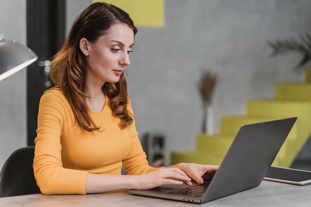 Seitenansicht Frau, die am Laptop arbeitet