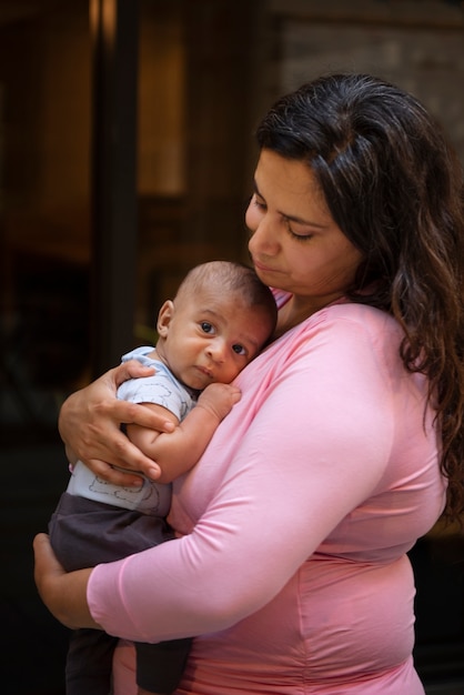 Kostenloses Foto seitenansicht frau, die baby hält