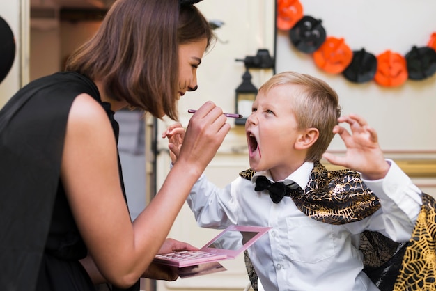 Seitenansicht Frau, die Kindergesicht malt