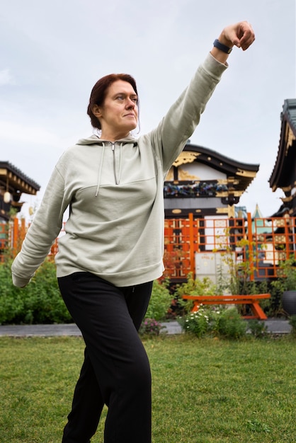 Kostenloses Foto seitenansicht frau, die tai chi praktiziert