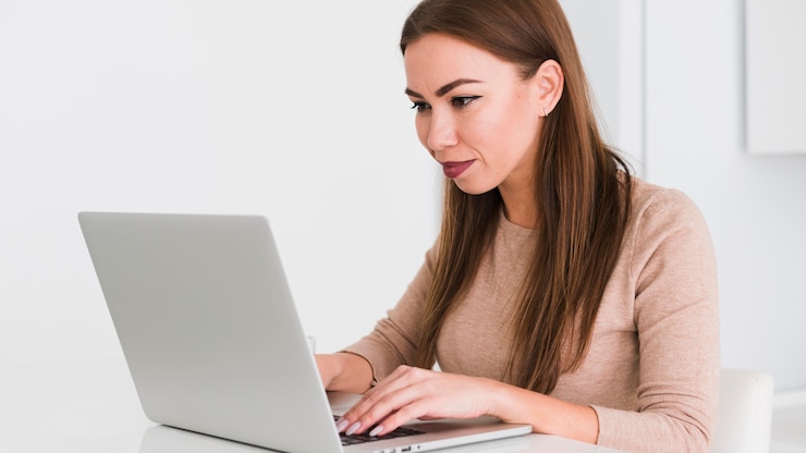 Kostenlose Foto seitenansicht frau, die von zu hause auf ihrem laptop arbeitet