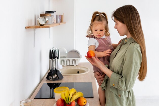 Seitenansicht Frau mit Kind in der Küche