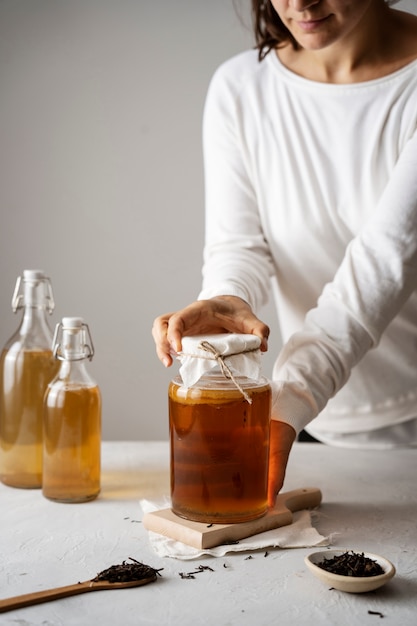 Seitenansicht Frau mit Kombucha-Glas