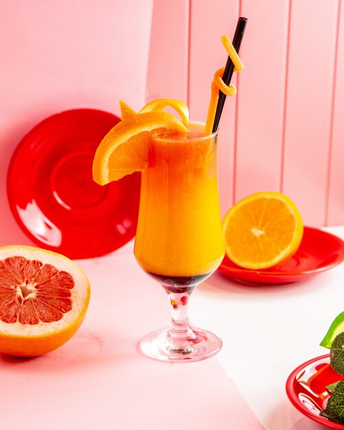 Seitenansicht frisch gepresste Grapefruit mit Orangensaft mit Grapefruitscheiben und Orange