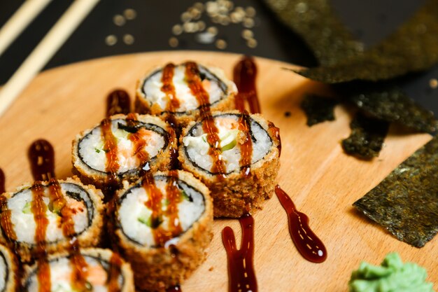 Seitenansicht gebratene Brötchen mit Soße auf einem Ständer mit Wasabi