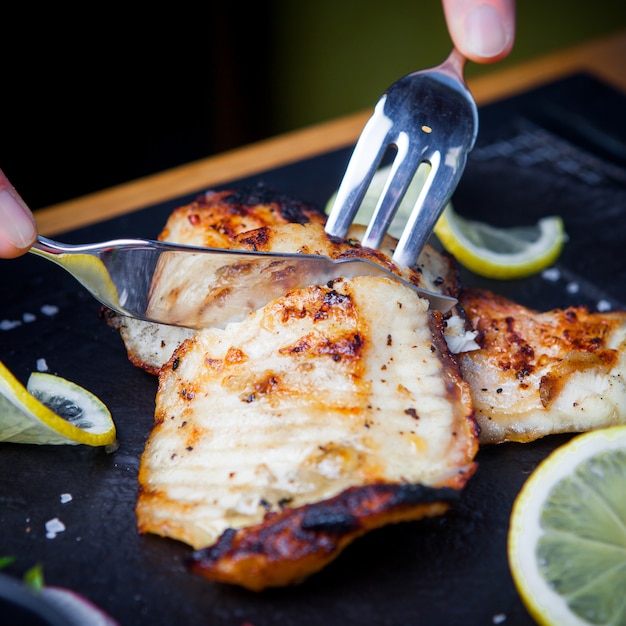 Seitenansicht gebratener Fisch mit Messer und Gabel