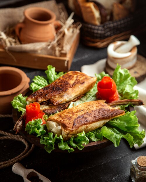 Seitenansicht gebratenes Fleisch in Fladenbrot auf Salat mit verzierten Karotten