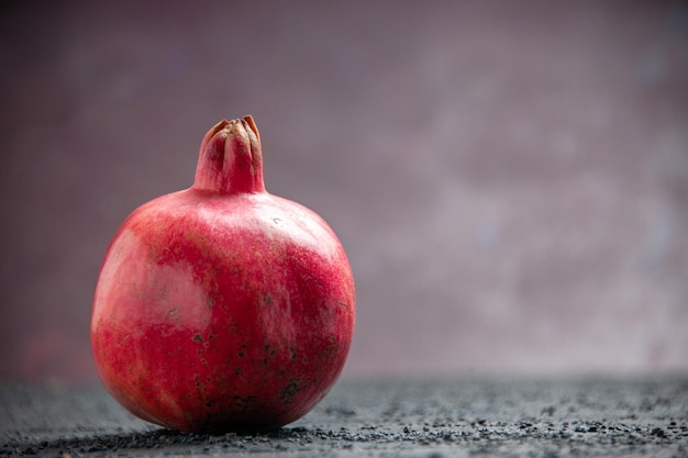 Seitenansicht Granatapfel roter Granatapfel auf dem grauen Tisch auf lila Hintergrund