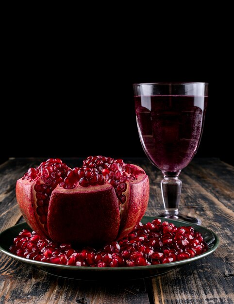 Seitenansicht Granatapfelkerne mit Glas Saft