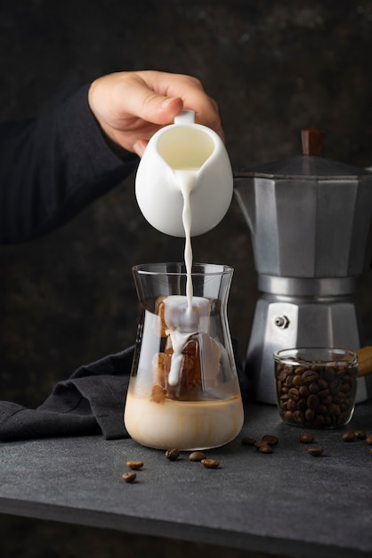 Seitenansicht Hand, die Milch in Tasse gießt