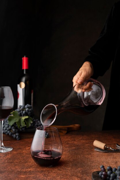 Seitenansicht Hand gießt Wein in Glas