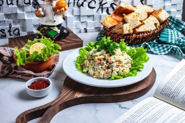 Seitenansicht Hauptsalat auf Salat mit Brot und einer Zitronenscheibe auf dem Tisch
