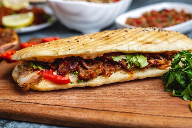 Seitenansicht Hühnerdöner mit Tomatengrün und Salat im Brot