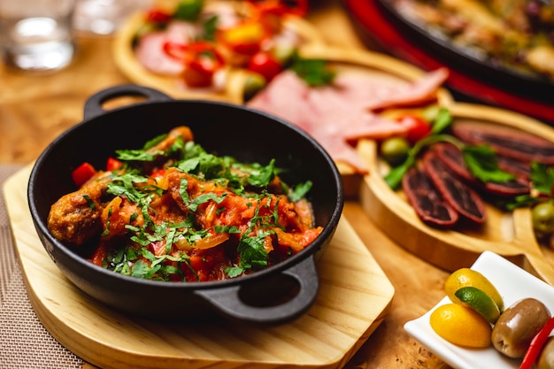 Seitenansicht Hühnerragout gebratener Hühnertrommelstock mit Zwiebel-Paprika und Gemüse auf dem Tisch