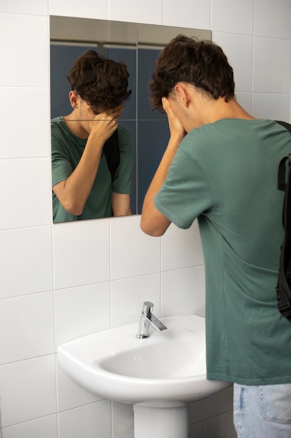 Kostenloses Foto seitenansicht junge weint im badezimmer