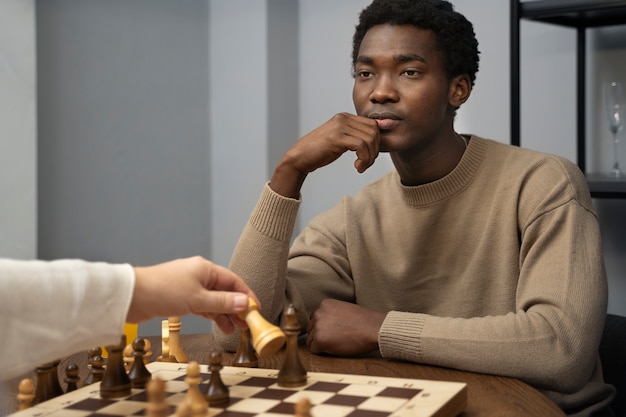 Seitenansicht junger Mann spielt Schach