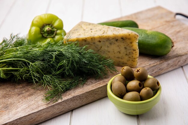 Seitenansicht Käse mit Gurken mit Paprika auf einem Ständer mit Oliven auf einem weißen Teller