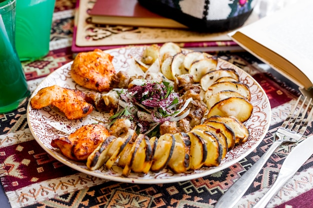 Kostenloses Foto seitenansicht kebab gehackte kartoffel mit fettem schwanz mit hühnchen-kebab und zwiebeln