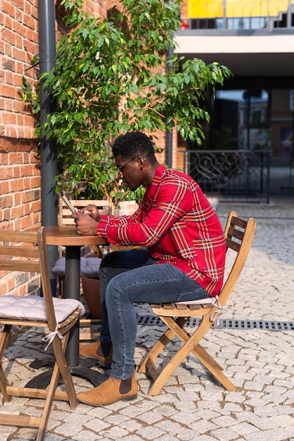 Kostenloses Foto seitenansicht lange ansicht des mannes, der am tisch sitzt