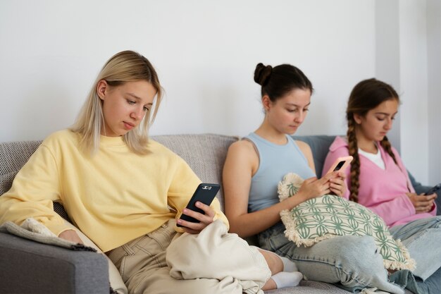 Seitenansicht Mädchen auf der Couch mit Smartphones