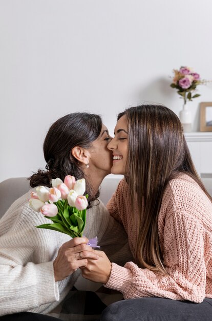 Seitenansicht-Mädchen, das der Mutter Blumen anbietet