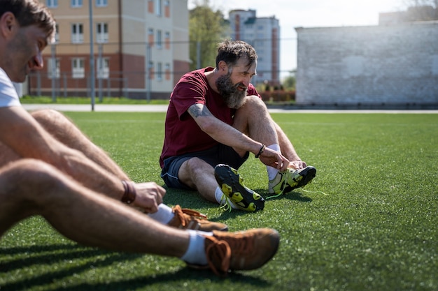 Kostenloses Foto seitenansicht männer auf fußballplatz