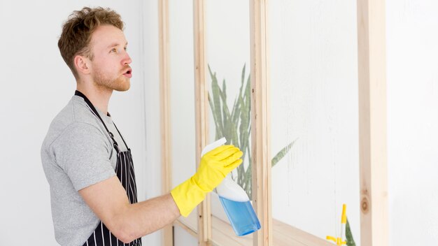 Seitenansicht Mann, der Fenster putzt